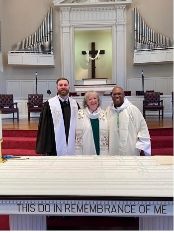 Three vested Catholic priest with Rev Mary Foley in the center