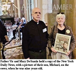 Father Vic and Mary DeSantis hold a copy of the New York Daily News, with a picture of their son, Michael, on the cover, when he was nine years old.